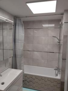 łazienka z wanną, umywalką i prysznicem w obiekcie Apartament 1 SUPER VIP Królewiecka centrum w mieście Mrągowo