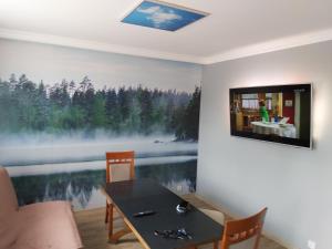 salon ze stołem i telewizorem na ścianie w obiekcie Apartament 1 SUPER VIP Królewiecka centrum w mieście Mrągowo