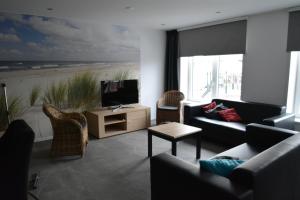 sala de estar con sofá y TV con playa en appartement Dorpsplein 35 Koudekerke, en Koudekerke