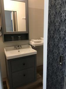 a bathroom with a sink and a mirror at The Originals Boutique, Hôtel Victoria, Châtelaillon-Plage in Châtelaillon-Plage