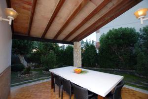 una mesa blanca y sillas bajo un techo de madera en Villa Torrent, en Puerto de Alcudia