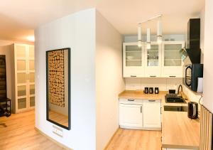 a kitchen with white cabinets and a wall with a wine rack at apartament Forest Karpacz in Karpacz