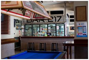 a bar with three stools and a pool table at Hurley's Bar & Bistro in Kyabram