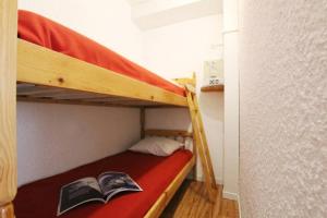 - un lit superposé avec un livre sur la couchette inférieure dans l'établissement Studio idéal 2 personnes et/ou avec 2 enfants, à Briançon