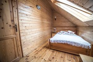 a bedroom with a bed in a wooden room at Apartamenty na Kasztelańskiej in Spytkowice