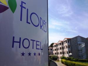 a sign for a hotel in front of a building at Hotel Flores in Poreč