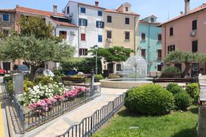 a park with pink and white flowers and buildings at Lighthouse.Izola in Izola