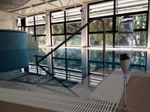 a room with a glass window with a bath tub at Hotel Flores in Poreč