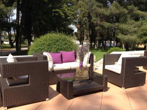 three wicker chairs and a table on a patio at Hotel Flores in Poreč