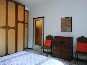 a bedroom with a bed and two chairs and a dresser at Vistalago 55 B in Como