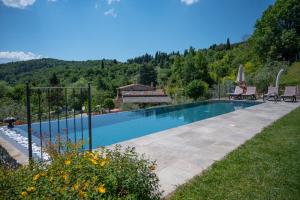 a swimming pool in a yard next to a house at Podere Fontanino in Arezzo