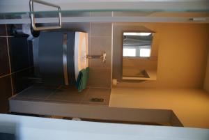 una pequeña cocina con lavabo y espejo en Guest House Feliz, en Lovaina