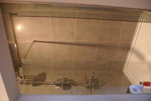 a shower stall with a towel rack on the wall at Guest House Feliz in Leuven