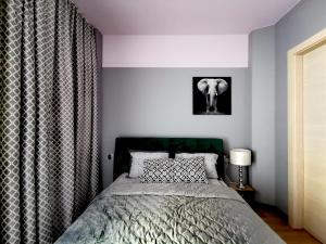 sypialnia z łóżkiem i obrazem słonia na ścianie w obiekcie Villa Garden Jagiellończyka w Olsztynie