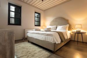a bedroom with a large bed and two windows at Κονάκι in Papingo