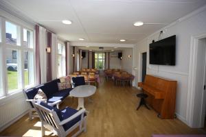 a room with a waiting room with chairs and a piano at Semesterhemmet Sommarro in Brännefjäll