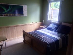 a bedroom with a bed and a window at Maison Bois "Alaska" in Rochecorbon