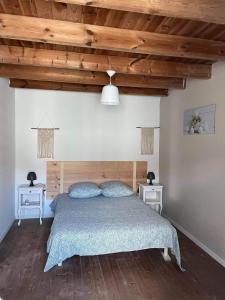 1 dormitorio con 1 cama y 2 mesitas de noche en charmante maison de village renovée, en Bazoges-en-Pareds