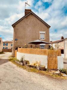 una casa con una valla delante de un edificio en charmante maison de village renovée, en Bazoges-en-Pareds