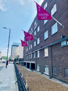 uma fila de bandeiras cor-de-rosa no lado de um edifício em Hotel Lily em Londres