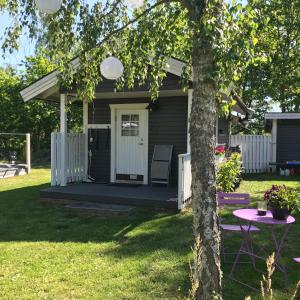 een tiny house met een veranda en een tafel bij Stuga på Öland in Algutsrum