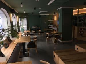 Un restaurante con mesas y sillas de madera y paredes verdes. en Hotel Alda Jolio Jaca, en Jaca