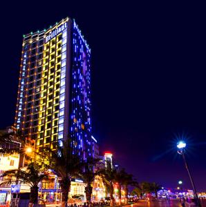 un edificio alto con luces azules por la noche en Brilliant Hotel, en Da Nang