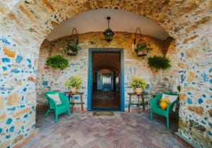 a room with a stone wall and two tables and chairs at Residenza Golfo Degli Ulivi in Caprioli