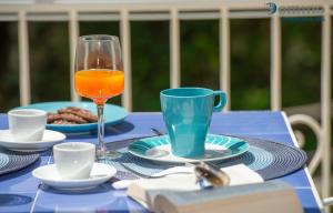 una mesa azul con un vaso de zumo de naranja y un libro en Casa Laurito, en Positano