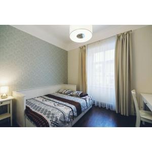 a bedroom with a bed and a desk and a window at Просторі апартаменти в центрі Львова in Lviv