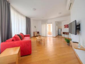 ein Wohnzimmer mit einem roten Sofa und einem TV in der Unterkunft Seaside Rest Apartments in Budva