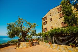 a tree in front of a building next to the ocean at Residenza Golfo Degli Ulivi in Caprioli