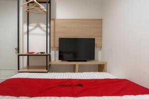 um quarto com uma cama e uma televisão de ecrã plano em RedDoorz near Seasons City Mall 3 em Jakarta