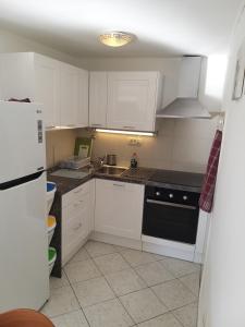 a kitchen with white cabinets and a black stove top oven at Guest House Zohil in Rovinj
