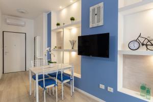 un salon avec une table et une télévision sur un mur bleu dans l'établissement Cortevecchia#13, à Ferrare