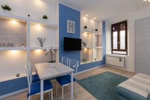 un soggiorno con parete con accento blu, tavolo e sedie di Cortevecchia#13 a Ferrara