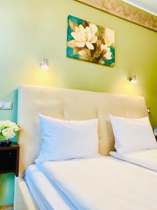 シビウにあるStyle Residenceの白い枕と壁画付きのベッド