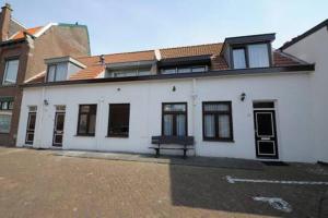 a white building with a bench in front of it at Hotel & Appartementen Bella Vista in Scheveningen