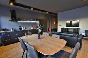 ein Esszimmer und eine Küche mit einem Holztisch und Stühlen in der Unterkunft Akureyri Luxury Apartments in Akureyri