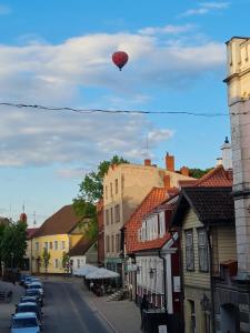 a red heart kite flying over a city street at Camino Cesis in Cēsis