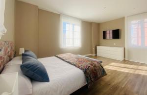 1 dormitorio con 1 cama y TV en la pared en Casa Vacacional Galiana, en Avilés