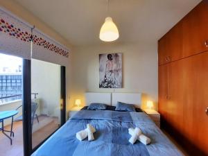 a bedroom with a large blue bed with two pillows at Albert's apartments in Larnaca