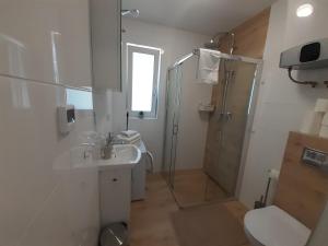 W łazience znajduje się prysznic, umywalka i toaleta. w obiekcie Komfortowy apartament dwupoziomowy w cichej okolicy w Pobierowie +30 zdjęć