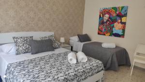 Un dormitorio con dos camas y un cuadro en la pared. en Casa Angela, en Salerno