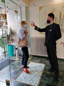 a man and a woman wearing masks standing in a room at Triton Hotel Piraeus in Piraeus