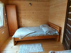 Habitación con cama en una cabaña de madera en Pokoje gościnne Ustronie en Zwierzyniec