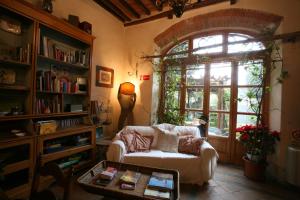 ein Wohnzimmer mit einem Sofa und einem Fenster in der Unterkunft Delizioso E Particolare Casale Con Piscina,cortona in Cortona