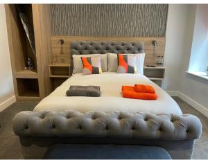 een slaapkamer met een groot bed met oranje kussens bij Mansion Court in Doncaster