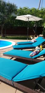 un grupo de tres piscinas con sombrilla en Villa Perfect Choice just 4 U, en Kaštela