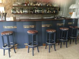 a bar with four stools in front of a counter at Manoir de Lan Kérellec in Trébeurden